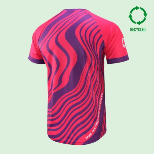Back view of a shotrt sleeved cycling t shirt with pink and purple swil design with a slogan reading "take the path less travelled", and a circular "recycled" logo at the top right of the image