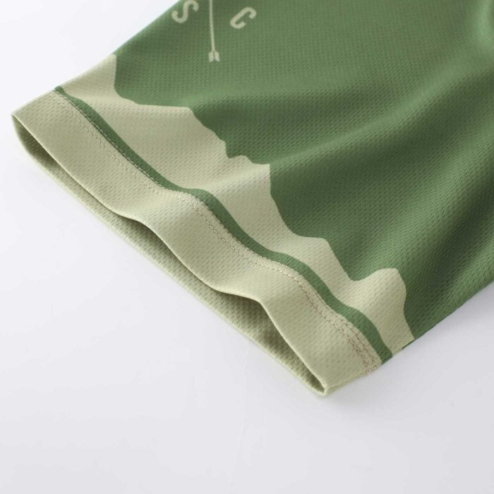 Close up shot showing the stitching on the end of a sleeve on a green and cream cycling top