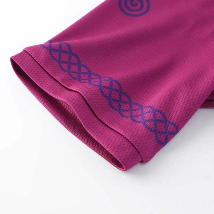 Close uo of the sleeve edge of a raspberry coloured cycling top with celtic band design around the sleeve