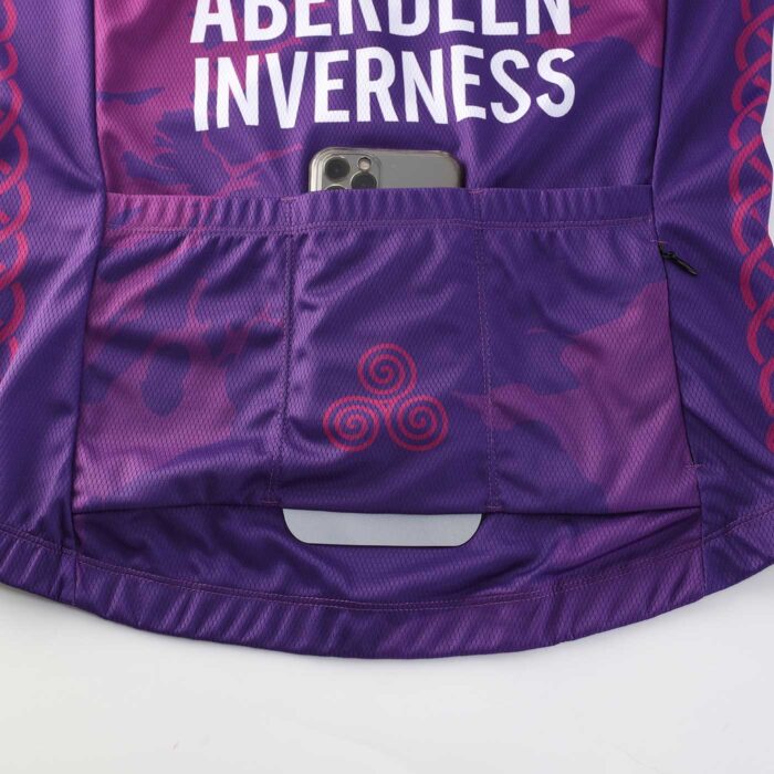 Close up showing three rear elasticated puch pockets and a reflective tab on the lower back of a cycling jersey