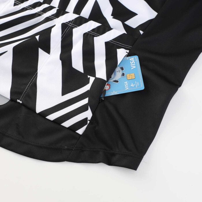 Close up showing a credit card sticking out of a zip up valuables pocket on a cycling jersey